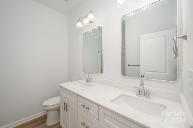 bathroom with vanity, toilet, and hardwood / wood-style flooring