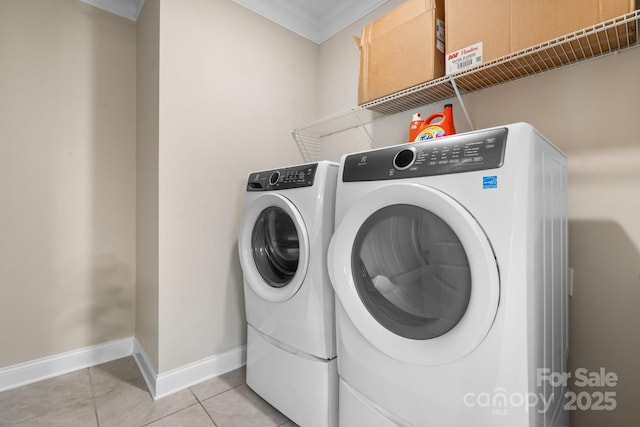 clothes washing area with separate washer and dryer, light tile patterned floors, and ornamental molding