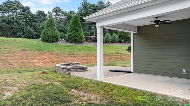 view of yard featuring ceiling fan, a patio area, and a fire pit