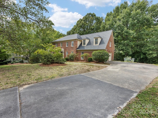 view of front of home with a garage and a front lawn