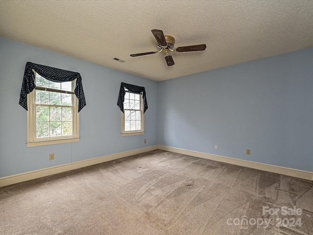 carpeted empty room featuring ceiling fan and a textured ceiling