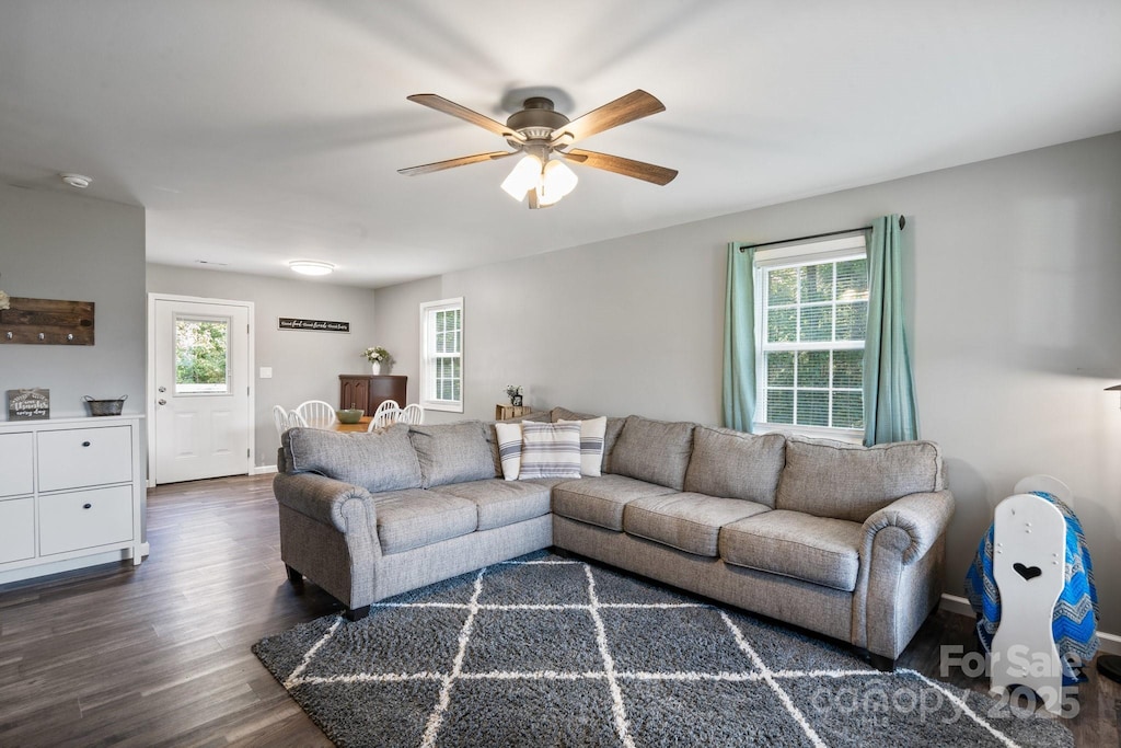 living room featuring dark hardwood / wood-style floors, ceiling fan, and a healthy amount of sunlight