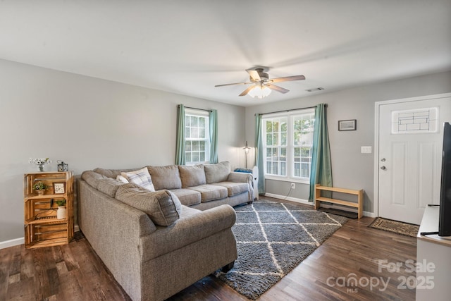 living room featuring ceiling fan and dark wood-type flooring