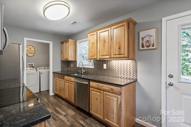 kitchen with sink, stainless steel appliances, dark hardwood / wood-style floors, independent washer and dryer, and backsplash