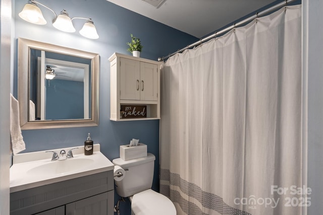 bathroom featuring a shower with shower curtain, ceiling fan, toilet, and vanity