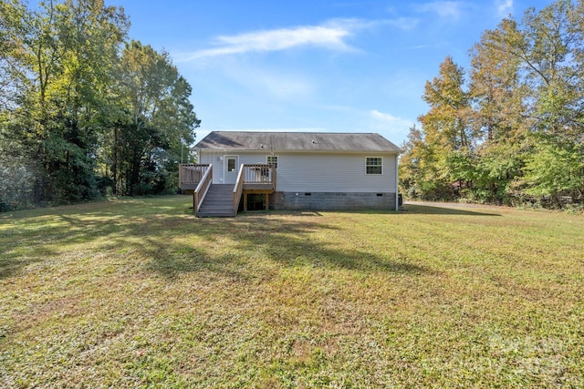 back of property featuring a yard and a wooden deck