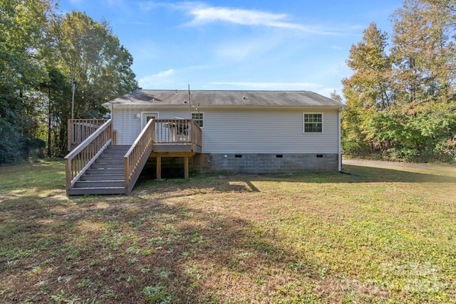 back of property featuring a lawn and a wooden deck