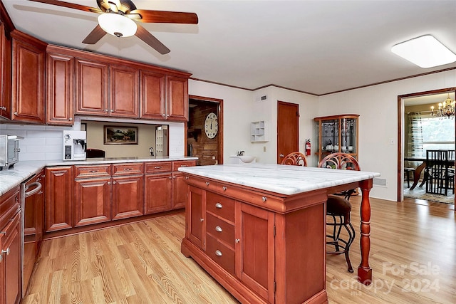 kitchen featuring a kitchen island, decorative backsplash, stainless steel dishwasher, a breakfast bar area, and light hardwood / wood-style flooring