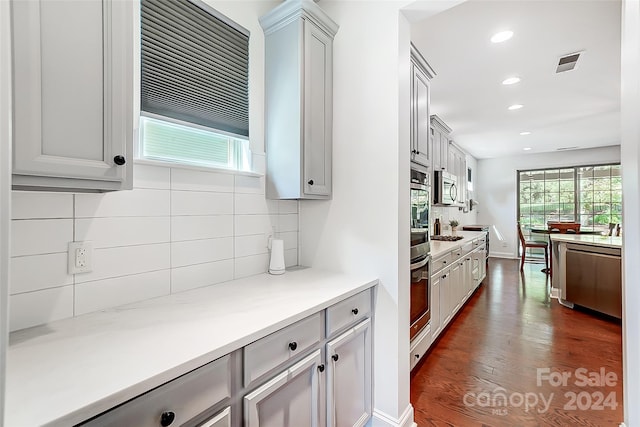 kitchen featuring gray cabinets, decorative backsplash, and dark hardwood / wood-style floors