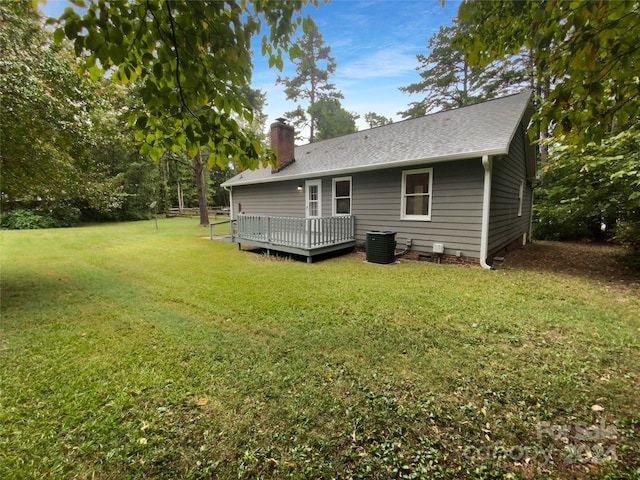 back of property featuring a lawn, cooling unit, and a wooden deck