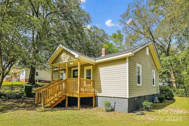 view of front of house with covered porch and a front yard