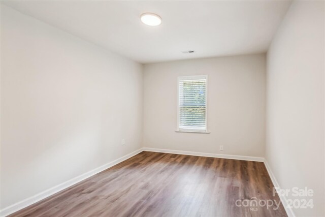 unfurnished room with dark hardwood / wood-style flooring