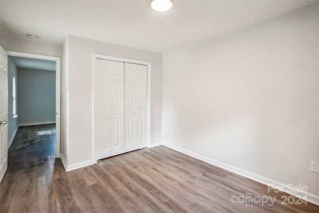 unfurnished bedroom featuring light hardwood / wood-style flooring and a closet