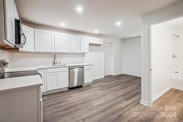 kitchen featuring sink, tasteful backsplash, white cabinetry, stainless steel appliances, and light wood-type flooring