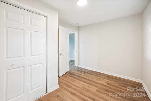 unfurnished bedroom featuring light wood-type flooring and a closet