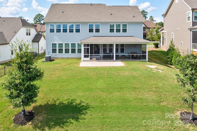 rear view of property with a sunroom, a yard, and cooling unit