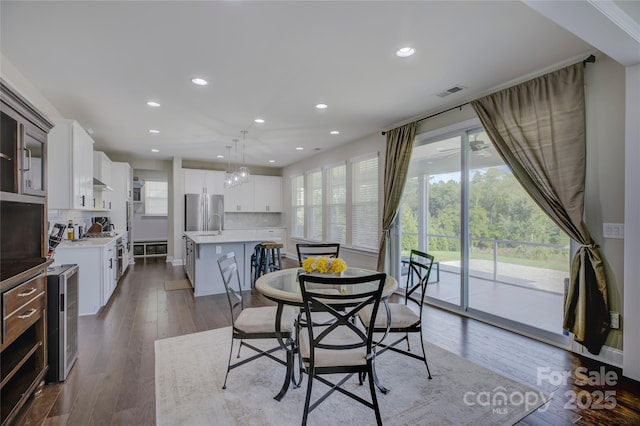 dining room featuring plenty of natural light, beverage cooler, and hardwood / wood-style floors