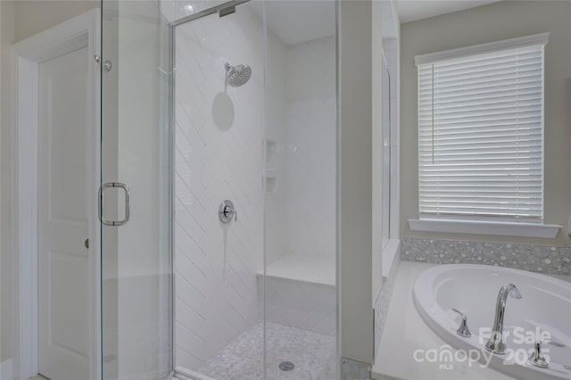 bathroom featuring shower with separate bathtub