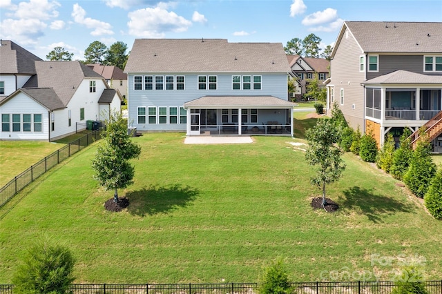 rear view of property featuring a sunroom and a yard