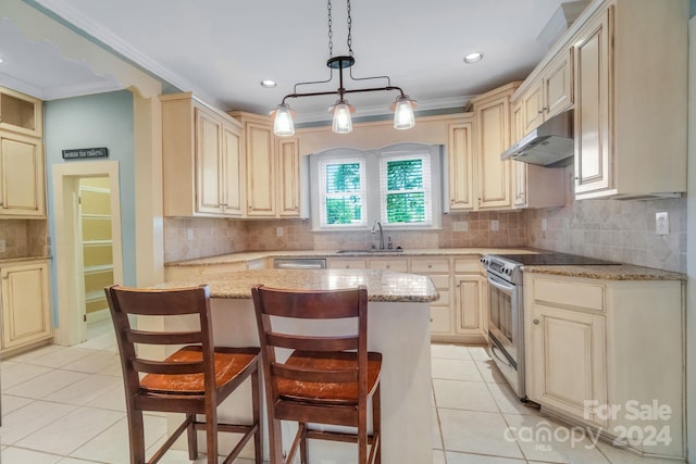 kitchen with sink, appliances with stainless steel finishes, a kitchen bar, and a center island