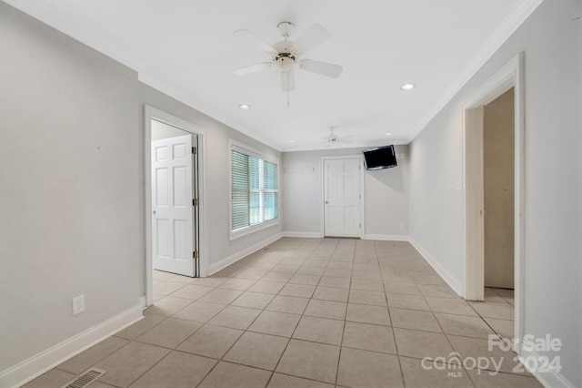 tiled empty room with ceiling fan and crown molding