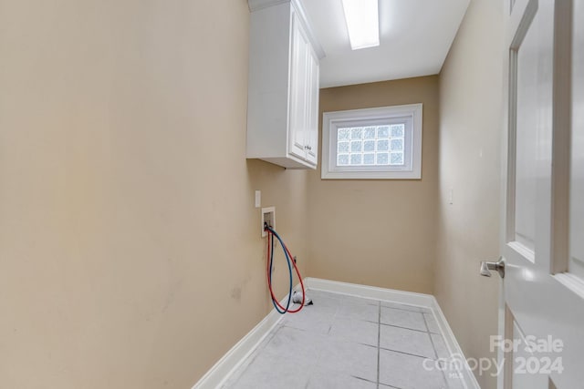 laundry room featuring cabinets, hookup for a washing machine, and light tile patterned floors