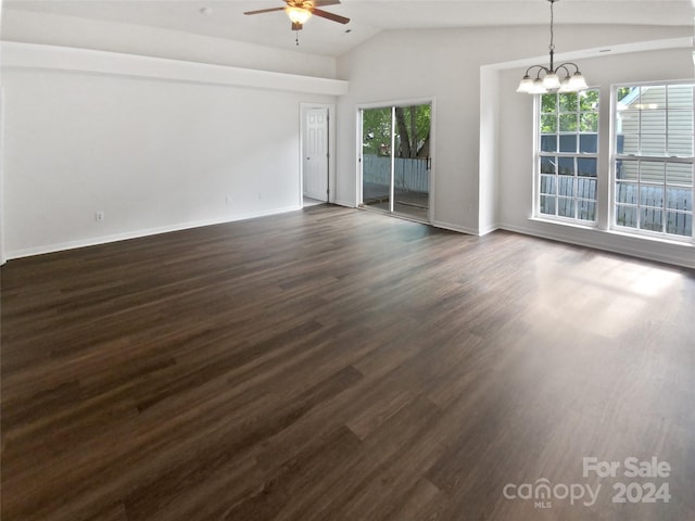 empty room featuring ceiling fan with notable chandelier, lofted ceiling, and dark hardwood / wood-style flooring