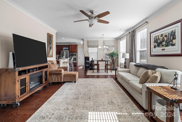 living room featuring crown molding, ceiling fan with notable chandelier, and dark wood-type flooring