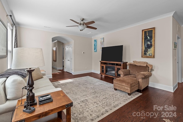 living room featuring crown molding, a fireplace, dark hardwood / wood-style flooring, and ceiling fan