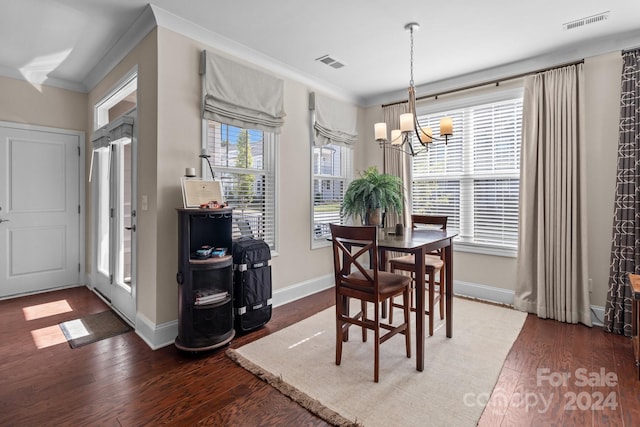 dining room with an inviting chandelier, dark hardwood / wood-style floors, and crown molding