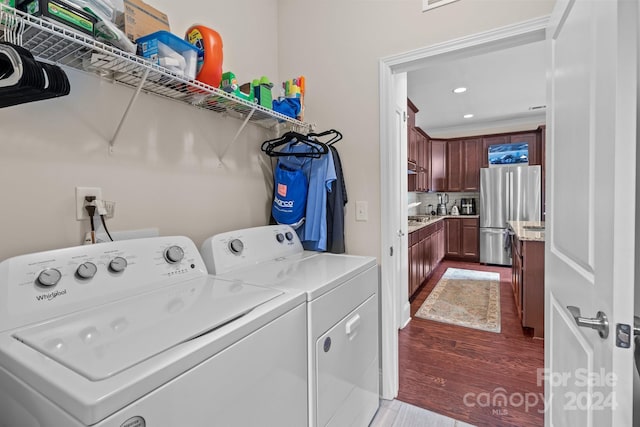 clothes washing area featuring dark wood-type flooring and washing machine and clothes dryer