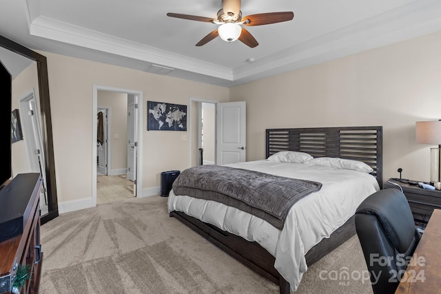 carpeted bedroom featuring a tray ceiling and ceiling fan