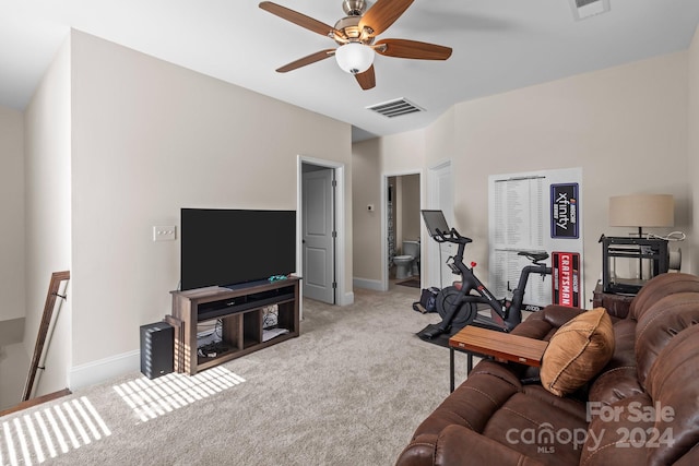 carpeted living room with ceiling fan