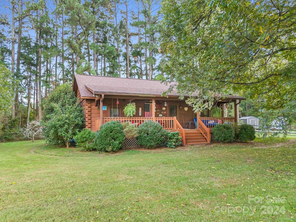 log-style house featuring a deck and a front lawn