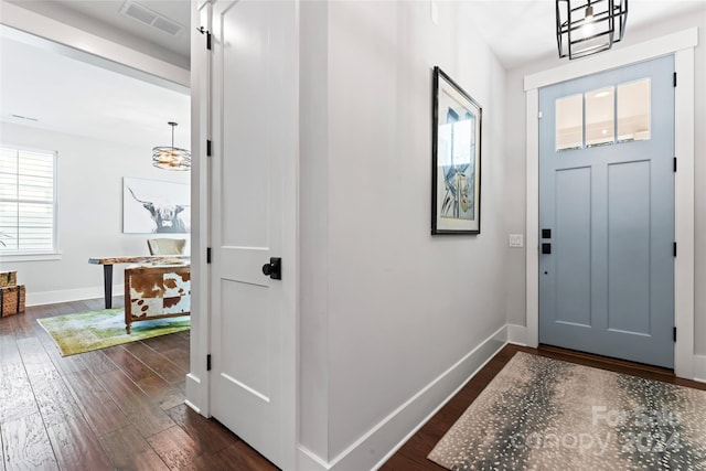 foyer with a chandelier and dark hardwood / wood-style flooring