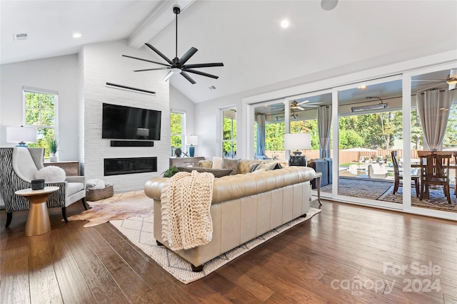 living room featuring beamed ceiling, wood-type flooring, a fireplace, high vaulted ceiling, and ceiling fan