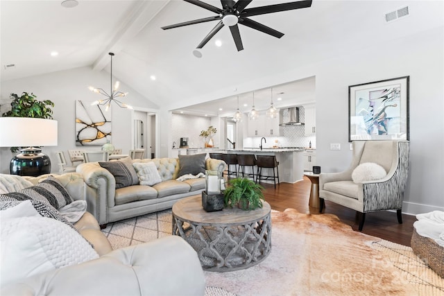 living room featuring light hardwood / wood-style floors, sink, vaulted ceiling with beams, and ceiling fan