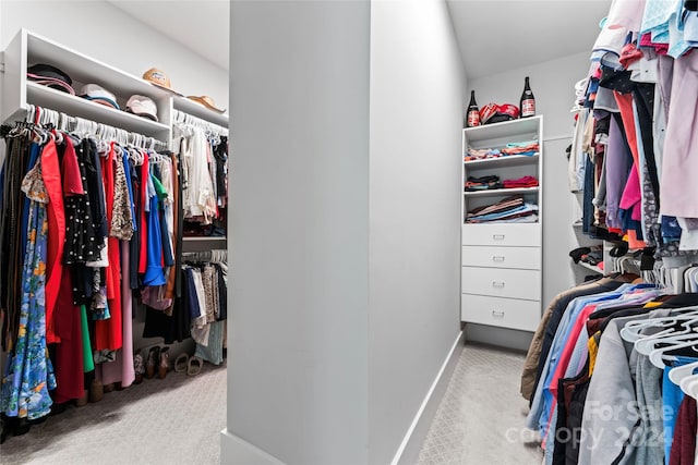 walk in closet featuring light carpet