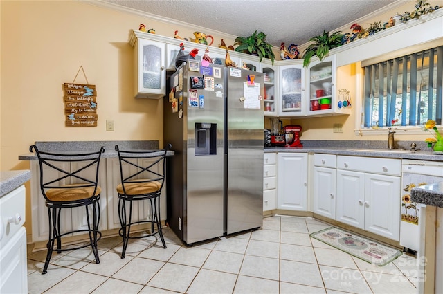 kitchen featuring a textured ceiling, crown molding, sink, stainless steel fridge with ice dispenser, and white cabinetry