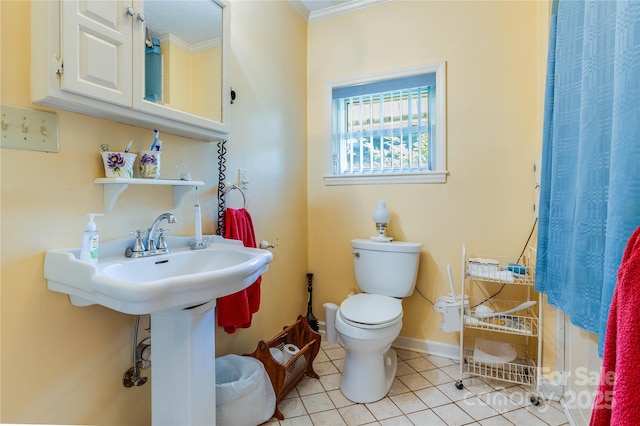 bathroom featuring tile patterned floors, crown molding, and toilet