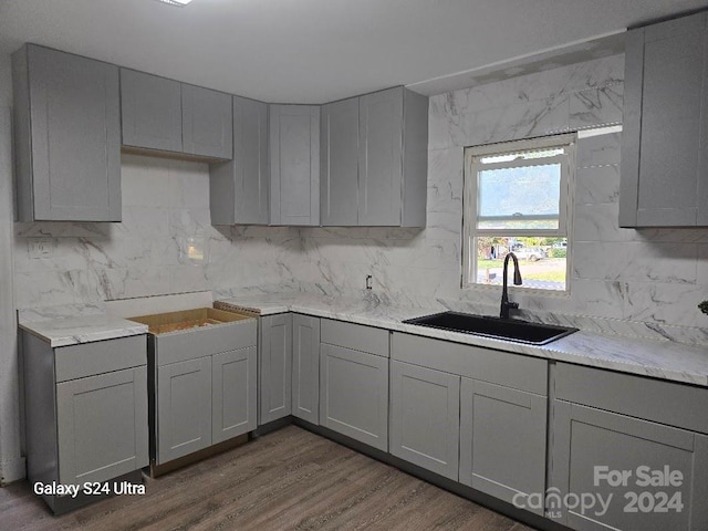 kitchen with dark wood-type flooring, sink, decorative backsplash, and gray cabinetry