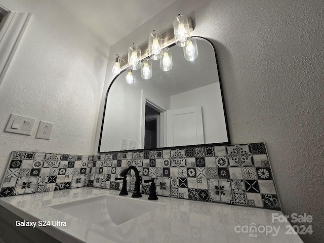 bathroom with decorative backsplash, lofted ceiling, and vanity