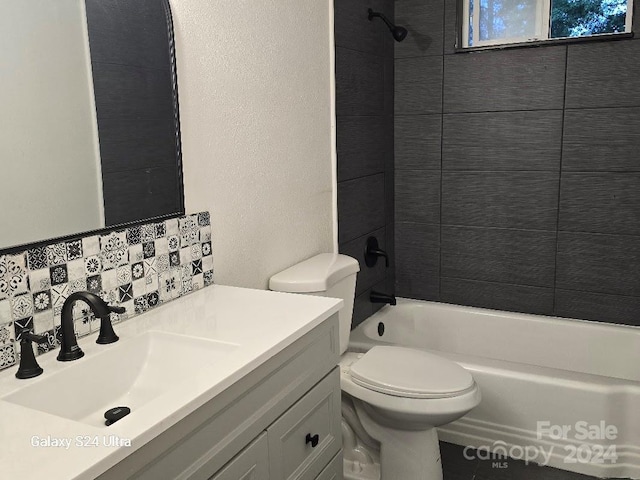 full bathroom featuring tiled shower / bath combo, decorative backsplash, vanity, and toilet