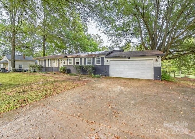 ranch-style house featuring a front lawn and a garage