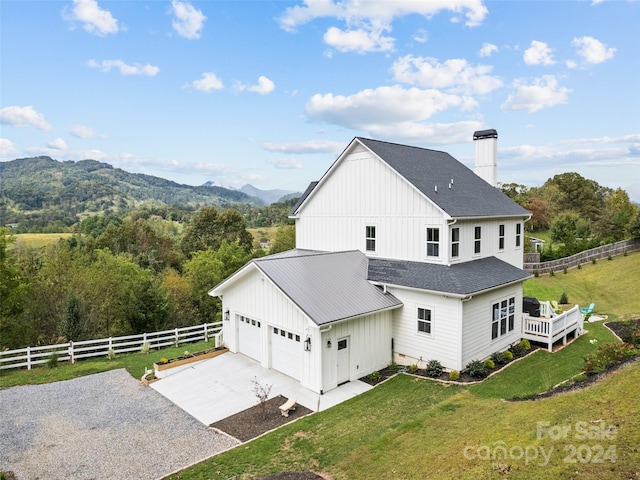 exterior space with a mountain view, a garage, and a yard