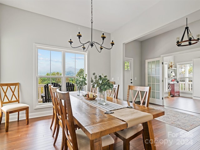 dining space featuring dark hardwood / wood-style flooring, an inviting chandelier, and plenty of natural light