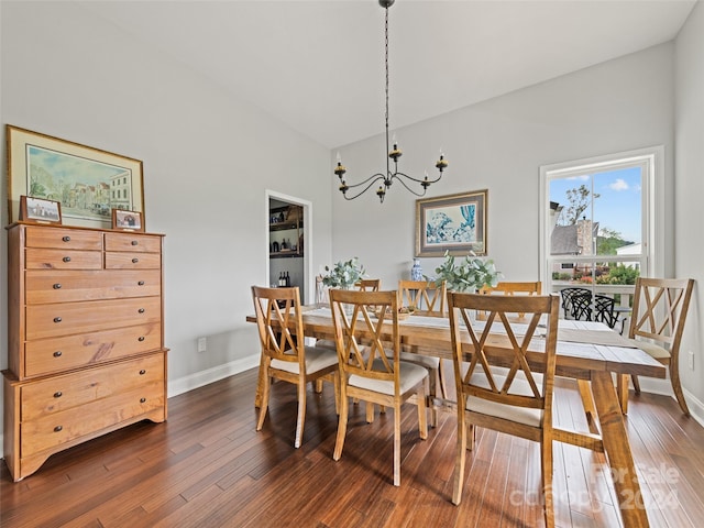 dining space featuring lofted ceiling, an inviting chandelier, and dark hardwood / wood-style flooring