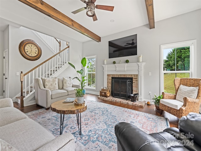 living room with a wealth of natural light, wood-type flooring, and beam ceiling