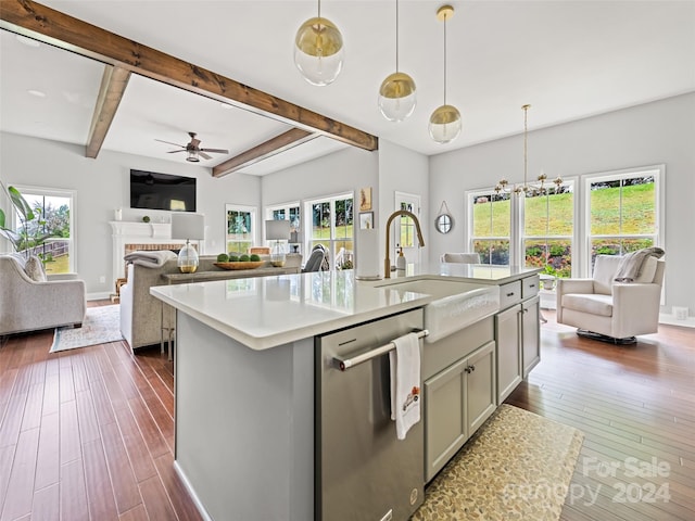 kitchen featuring pendant lighting, a wealth of natural light, stainless steel dishwasher, and sink