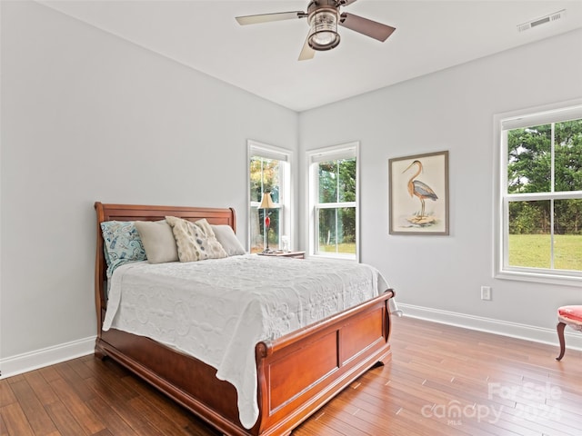 bedroom featuring light hardwood / wood-style floors, multiple windows, and ceiling fan